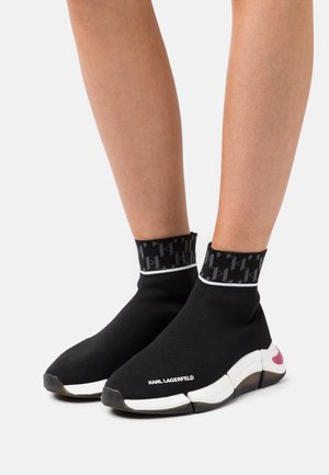 Czarne sneakersy w stylu skarpetkowym z teksturowanym, czarno-białym wzorem przy mankiecie, białymi akcentami na podeszwie oraz brandingiem „KARL LAGERFELD” z przodu.