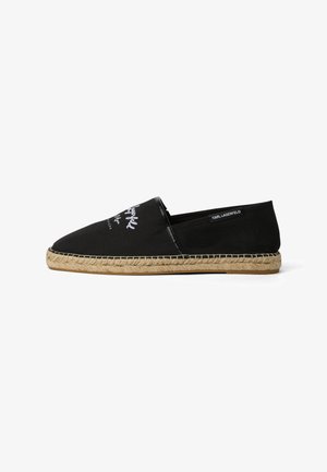 Crna espadrila na navlačenje s bijelim tekstom na gornjem dijelu i tkanim đonom od jute, s oznakom Karl Lagerfeld sa strane.
