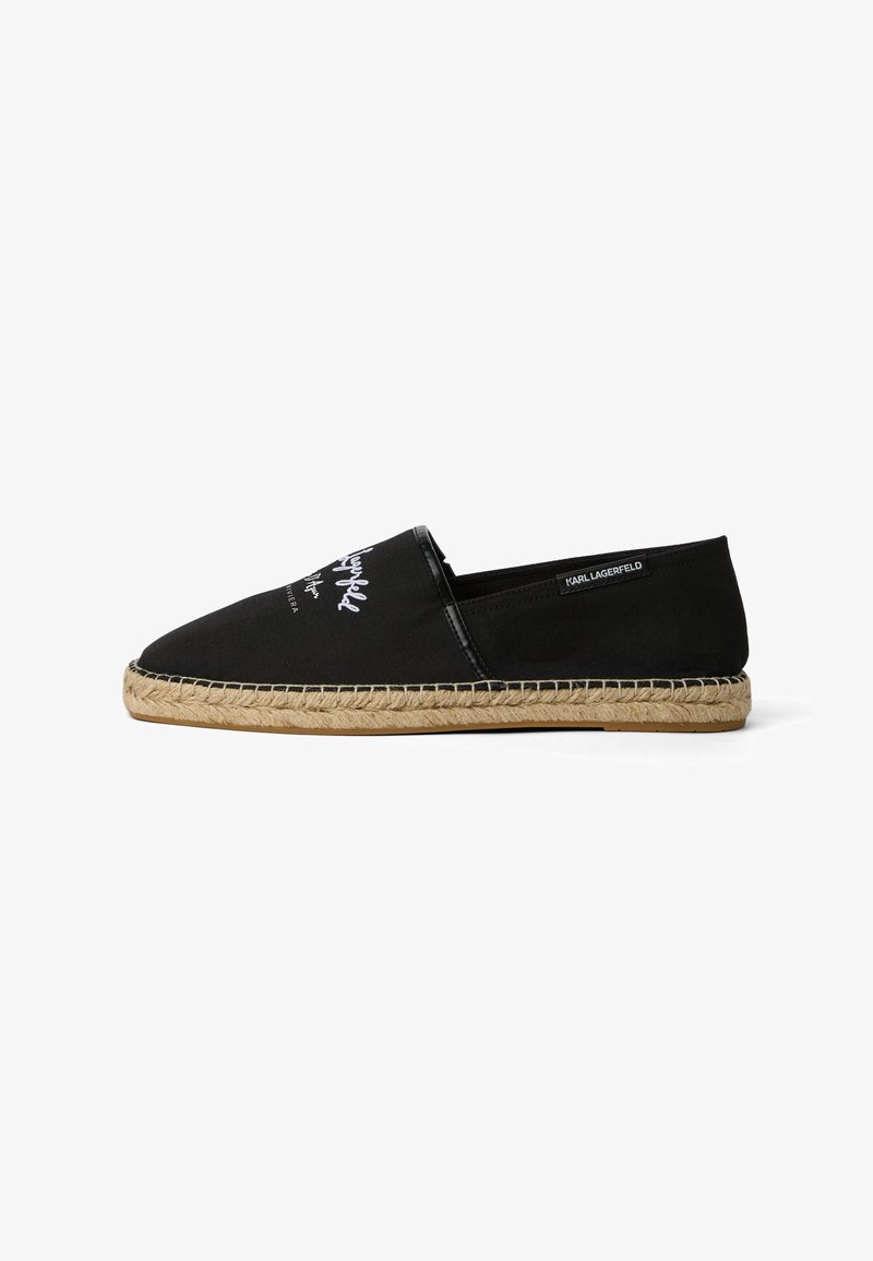 Espadrille noire à enfiler avec texte blanc sur la tige et semelle en jute tissée, étiquetée Karl Lagerfeld sur le côté.