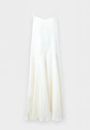 Λευκό μάξι φόρεμα χωρίς μανίκια με λεπτές τιράντες και αέρινη, πολύστιχη φούστα που κρέμεται πάνω σε απλό φόντο.
