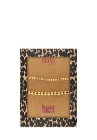 Braccialetti perla tono oro su un cartellino con motivo leopardato. Presentano una texture lucida e liscia e due design di perle distinti.
