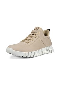 Beige bőr sportcipők fehér gumitalppal. Jellemzői közé tartozik a fűzős elülső rész, a kerek orr és a mintázott részletek a talpon.