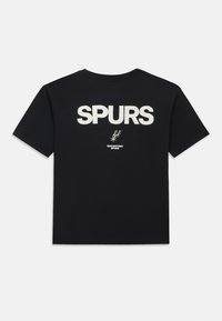 Črna bombažna majica s kratkimi rokavi in okroglim izrezom, na hrbtu s velikim belim napisom "SPURS" ter majhnim logotipom "SAN ANTONIO SPURS" pod njim.