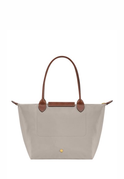 Hellgraue Tragetasche aus glattem Stoff mit braunen Lederakzenten, zwei stabilen Griffen und einer Vorderseite mit Tasche. Verfügt über einen Goldreißverschluss.