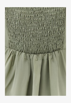 Groene jurk met een smockbustier en getextureerde plooien, gemaakt van lichtgewicht stof, wat zorgt voor een vloeiende silhouet.