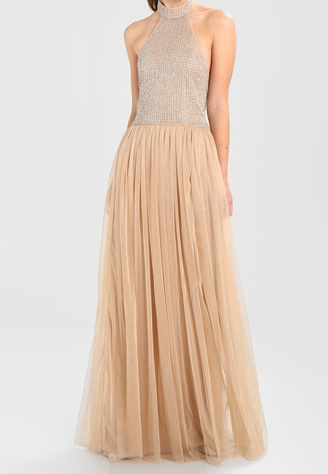 Beige halterneck-klänning med en kraftigt utsmyckad, pärlbroderad överdel och en svepande, plisserad tyllkjol som skapar en mjuk, lagrad textur.