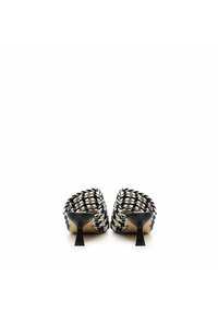 Black and white woven upper mules with a curved heel. Smooth inner lining and a distinctive, textured pattern on the exterior.