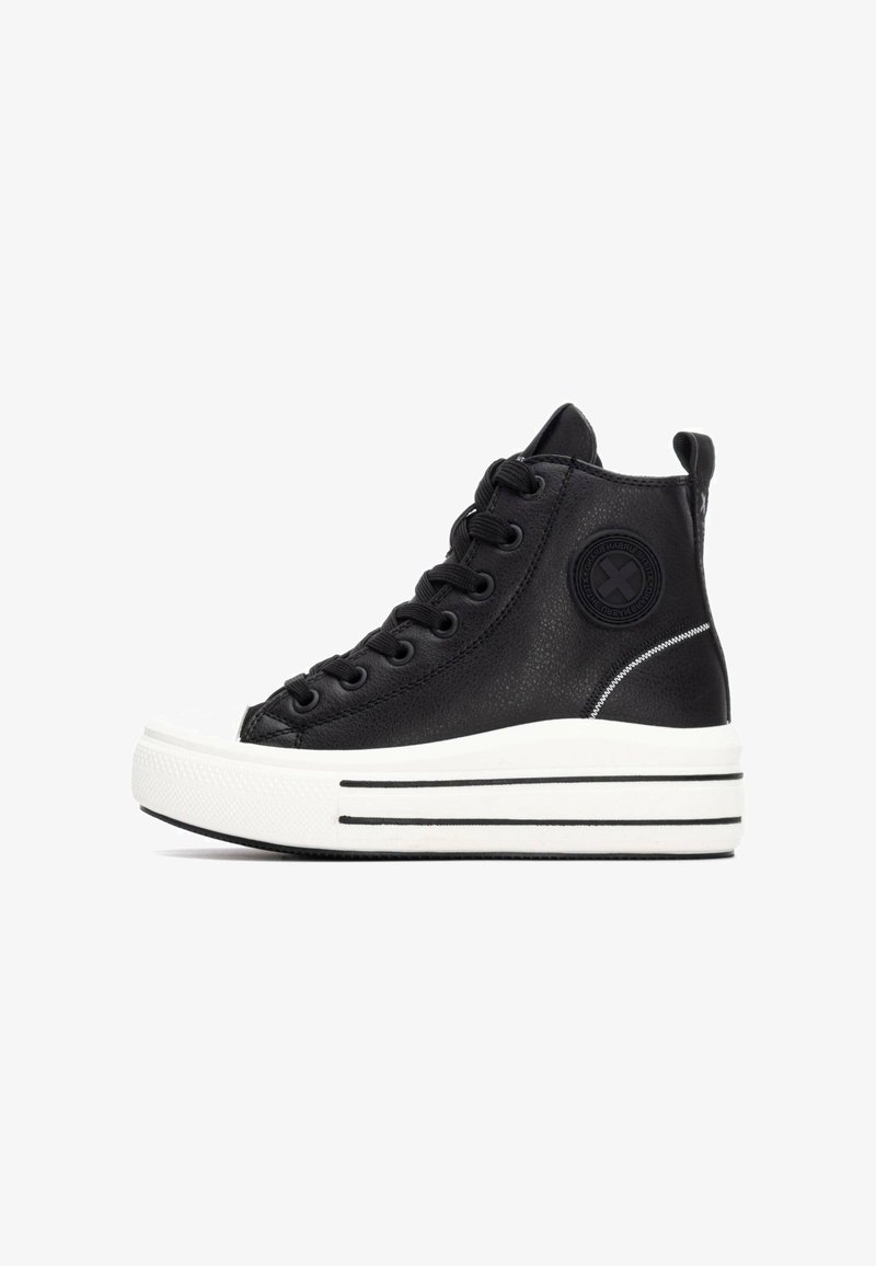 Zapatilla alta negra con un upper sintético texturizado, puntera de goma blanca y suela de plataforma con acentos de rayas en blanco y negro.