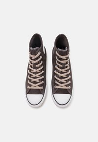 Wysokie sneakersy wykonane z ciemno-brązowego zamszu, z jasnobeżowymi sznurówkami, białą gumową osłoną na palce i wyściełaniem z fakturowanej tkaniny.