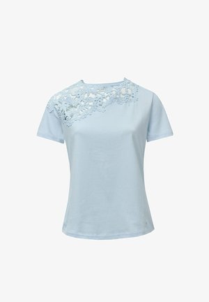 T-shirt à manches courtes bleu clair avec un design en dentelle florale sur l'épaule gauche. Fabriqué en tissu doux avec une texture lisse.