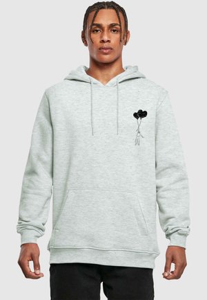 Hellgrauer Hoodie aus weichem Material, mit einer Vordertasche und einem Grafikmotiv eines Figuren, die schwarze Ballons auf der linken Brust hält.