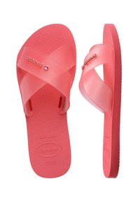 Sandales à enfiler Havaianas rose corail avec des brides translucides croisées et des semelles texturées, vues de dessus et de côté.
