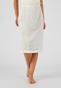 Gonna bianca in un tessuto liscio, con un bordo in pizzo all'orlo. Vita elastica per il massimo comfort. Piedi nudi e un design minimal.