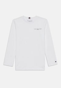 Hvit langermet t-skjorte laget av bomull, med en liten svart logo på venstre side og en stripete aksent på kragen.