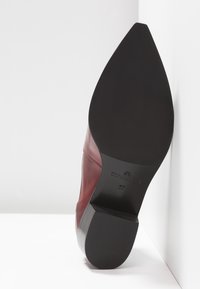 Semelle d'une chaussure en cuir bordeaux à bout pointu avec talon noir, taille 37, avec "Copenhagen" embossé sur la semelle.