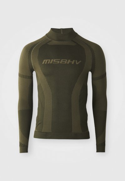 Hosszú ujjú hőszigetelő póló olívazöld színben, testhezálló kialakítással, magas nyakkal és kontrasztos csíkozott textúrával. A "MISBHV" márkaneve feltűnően látható.