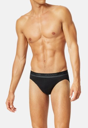 Schwarze Baumwollslips mit einem bequemen elastischen Bund, der den Text "uncover" in Grau trägt. Enganliegendes Design mit minimaler Bedeckung.