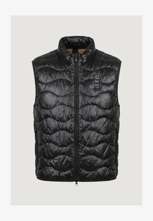 Chaleco negro acolchado sin mangas con cremallera frontal y pequeño parche con marca en la parte superior izquierda del pecho.