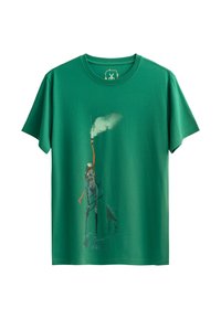 Groene katoenen t-shirt met een abstracte print van een personage dat een wolk van rook vasthoudt, met contrasterende kleuren en een soepele textuur.