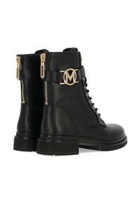 Botas de cuero negro hasta el tobillo con puntera redonda, cordones en la parte frontal, cremalleras laterales y un acento en forma de logo circular dorado en el detalle de la correa ajustable.