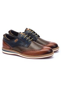 Brune og marineblå lædersko med brogue-design, der har en rund tå, kontrastsnørebånd og hvid gummisål med marineblå accenter.