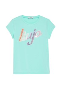 Světle modré tričko s krátkým rukávem vyrobené z měkké tkaniny, zdobené na přední straně lesklými multicolor kamínky se slovy "liu jo".
