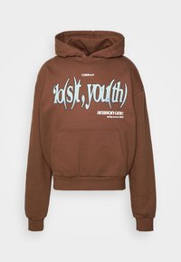 Brun kort hoodie i mjukt tyg. Har en framficka, snörning i huvan och djärv blå grafisk text på bröstet. Accenterad med vita detaljer.