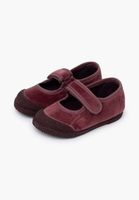 Scarpe Mary Jane in velluto bordeaux con punta arrotondata, cinturino regolabile e suola in gomma testurizzata. Presentano un design con ritagli e una fodera morbida.