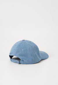 Căciulă din denim bleu deschis, cu textură verticală cu caneluri, vizor curbat și brâu ajustabil la spate. Design cu șase panouri, dotată cu găuri de ventilație.