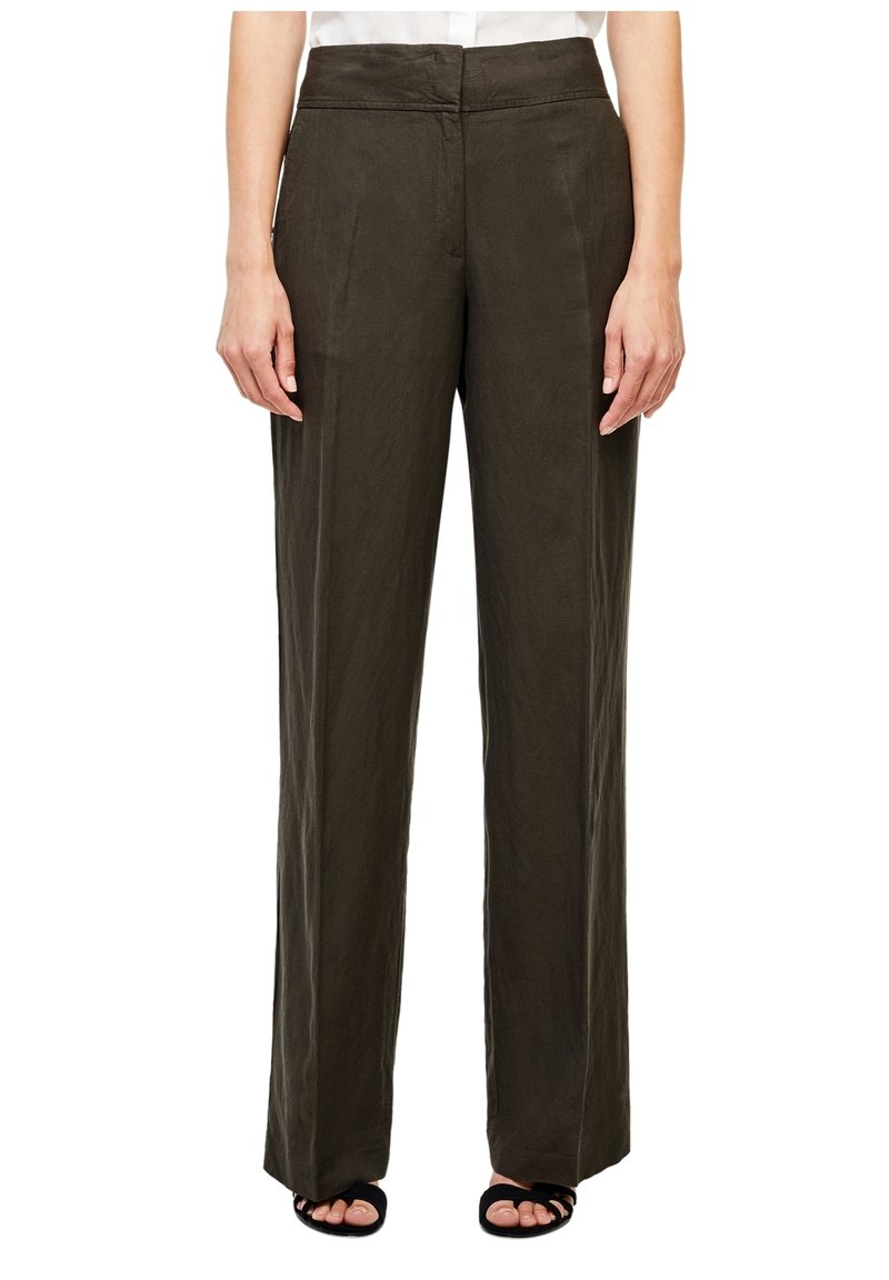 Pantalon marron taille haute à jambes larges porté avec des sandales noires à bout ouvert, présenté sur une personne de la taille aux pieds sur fond blanc.