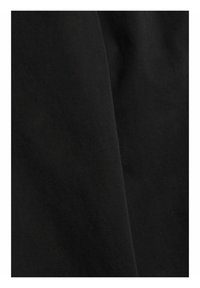 Gros plan sur un tissu noir lisse avec de subtiles plis et une texture mate.