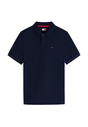 Tumesinine lühikeste varrukatega polo-särk, millel on kaks nuppu, klassikaline krae ja väike valge, punase ning sinise logoga vasakul rinnal.