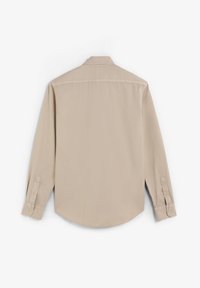 Camisa de manga larga beige con cuello abotonado, yugo trasero simple y puños de dos botones, hecha de una tela suave con una ligera textura.