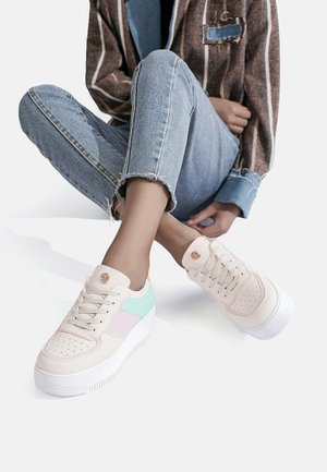 Sneaker platform con suola in gomma bianca, caratterizzate da dettagli in rosa pastello e verde menta su una tomaia liscia e testurizzata. Lacci piatti e forature.