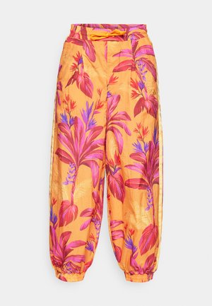 Pantalons harem en tissu orange ornés de grands motifs floraux roses et violets. Taille élastique avec cordon de serrage, chevilles côtelées.