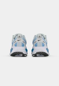 Une paire de chaussures de course Nike bleu et blanc vue de l'arrière sur un fond blanc uni.