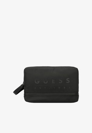 Beauty case in nylon nero con texture liscia, logo "GUESS" in rilievo, chiusura con zip e manico laterale per un facile trasporto.