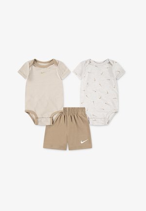 Due body body suit beige a maniche corte per neonati—uno a righe, l'altro con piccoli loghi—e pantaloncini beige coordinati con vita elastica, tutti con il logo Nike bianco.