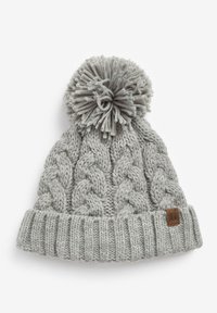 Harmaa kaapelikudottu pipo, jossa on uurteellinen resori ja fluffy pom-pom päässä. Sivussa on pieni ruskea nahkainen logo-merkki.