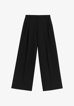 Mustat leveälahkeiset housut, jotka on valmistettu sileästä kankaasta. Niissä on etuvarsit, litteä vyötärö ja ei näkyvää metalliosaa tai koristeita.