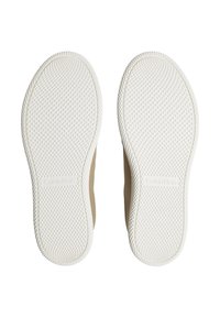 Zapatillas Calvin Klein con parte superior beige y suela de goma blanca. La suela presenta un agarre texturizado con patrón de diamante para mayor tracción.