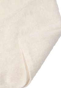 Ljust beige stickad tyg med en mjuk, fin struktur, vikt vid ena kanten, vilket visar den släta, jämna vävningen.
