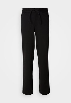 Pantalones de chándal negros con cinturilla ajustable, hechos de tela suave y elástica. Presentan un corte relajado con piernas rectas y sin bolsillos visibles.