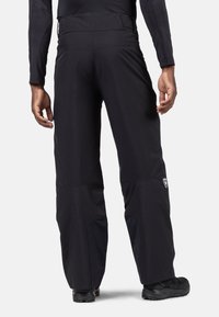 Pantaloni da sci neri impermeabili con vestibilità rilassata, vita regolabile e pannelli laterali a contrasto. Ideali per attività invernali.