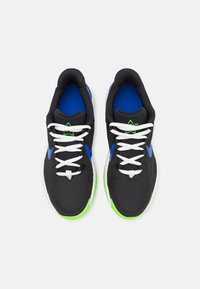Zwarte sportieve schoenen met een textuur bovenkant, blauwe accenten, witte veters en een groene zool. Heeft een gevoerde kraag en een logo.