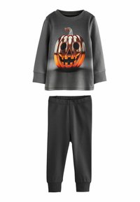 Zestaw do relaksu w tematyce Halloween zawierający szary top z długim rękawem z grafiką dyni i czarne spodnie z elastycznym paskiem.