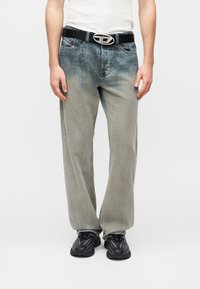 Ανοιχτό γκρι τζιν με φαρδιά μπατζάκια από τζιν βαμβάκι με ξεβάμμα. Συνδυασμένο με μαύρη ζώνη που διαθέτει μεταλλική οβάλ αγκράφα.