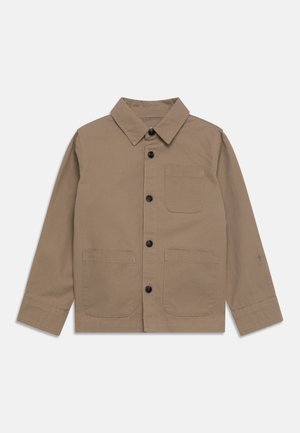 Beżowa koszula na guziki z długim rękawem, trzema czarnymi guzikami, jedną kieszenią na piersi oraz dwiema przednimi kieszeniami na dole, na białym tle.