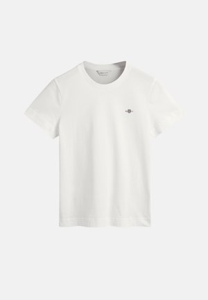 T-shirt en coton blanc avec un col rond, des manches courtes et un petit logo violet sur la poitrine gauche. Texture lisse, design classique.