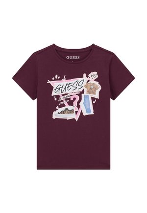 T-shirt bordeaux avec le texte « GUESS », un point d'interrogation rose et un graphisme d'un t-shirt imprimé léopard, baskets et jean bleu.